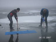 Taucher hauen Loch ins Eis